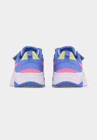 Ζεύγος αθλητικών παπουτσιών Puma σε μπλε, ροζ και κίτρινο χρώμα, εμφανιζόμενα από πίσω σε λευκό φόντο.