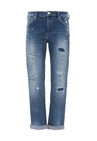 Jeans de mezclilla azul con puños enrollados, que presentan múltiples áreas desgastadas y rasgadas en las piernas delanteras y un cierre de botón en la cintura.