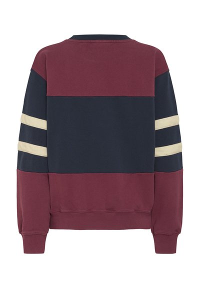 Burgundia ja tumesinise värviga puuvillane sviiter horisontaalsete värviblokkidega, millel on kreemjaid triipu varrukatel ning ribatud kaelus ja mansetid.