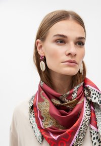 Silkescarf med en vinröd bas och leopard- och djurmotiv. Utsmyckad med en kraftig kant och varierade texturer.