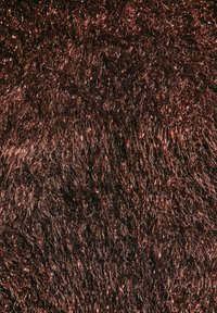 Materiale in pelliccia sintetica di color marrone rossiccio scuro con lunghe e morbide fibre. La texture è soffice e lucida con una leggera finitura metallizzata.