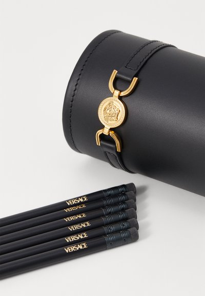 Caz cilindric negru din piele cu accesorii aurii și emblemă. Șase pensule de machiaj negre cu accente aurii "VERSACE".
