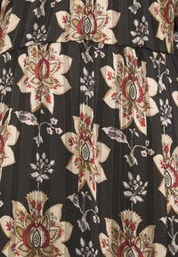 Tissu noir avec des motifs floraux beige, rouge et gris comprenant de grandes fleurs et de petites feuilles dans un motif répétitif.