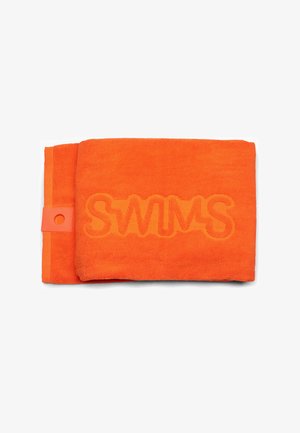 Serviette orange vif pliée avec le mot « SWIMS » embossé en grandes lettres au centre.