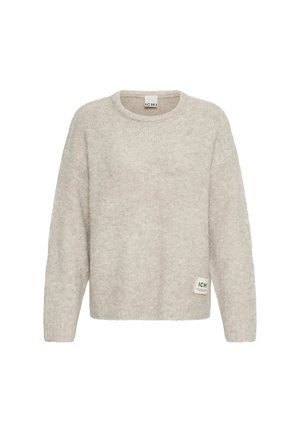 Jersey de punto beige claro de manga larga con cuello redondo y pequeña etiqueta de marca en la parte inferior delantera.