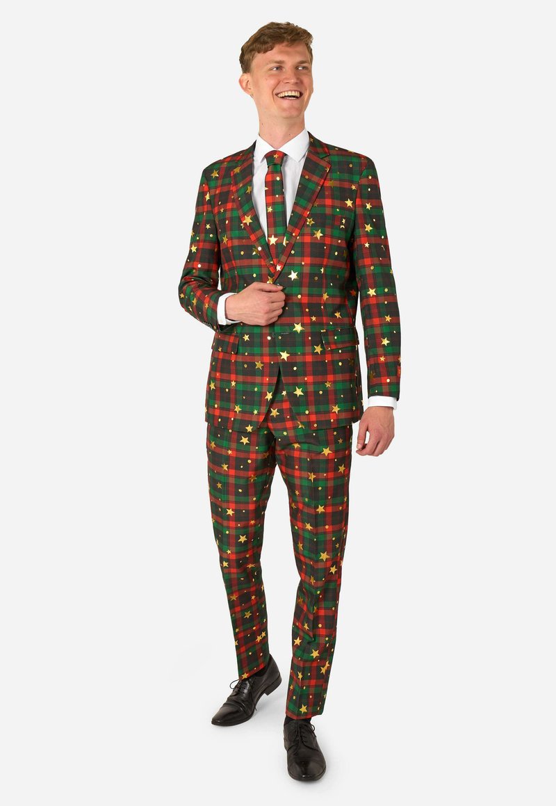 Grüner, roter und schwarzer Karosanzug mit goldenen Sternakzenten. Enthält ein tailliertes Jacket und passende Hose, getragen mit einem weißen Hemd und einer Krawatte.