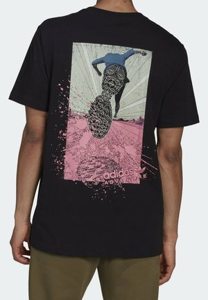 T-shirt en coton noir avec un imprimé graphique d'un coureur sur un fond rose et vert clair, agrémenté de touches éclaboussées et du texte « adidas ADVENTURE ».