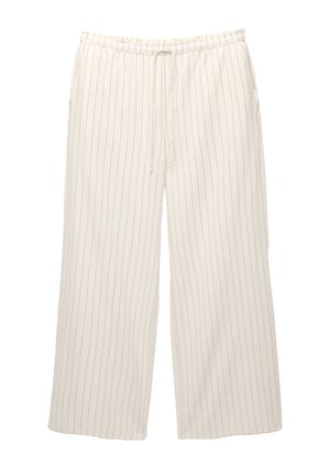 Pantalons larges couleur crème avec de fines rayures verticales noires, taille élastique et cordon de serrage ajustable. Tissu léger. Deux poches latérales.