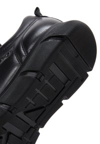 Sneaker nera con tomaia in pelle liscia, suola in gomma texture con un battistrada modellato per una buona aderenza e puntale rinforzato.