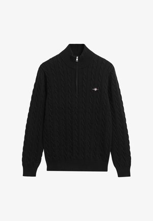 Svart kabelstrikket genser med halv-glidelås og liten brodert logo på brystet.