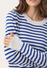 Niebiesko-biały sweter w paski z szerokim, zaokrąglonym dekoltem i prążkowanymi mankietami. Materiał wydaje się miękki i dzianinowy, z poziomymi paskami.