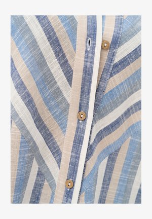 Zbliżenie na pasiasty lniany materiał z beżowymi, niebieskimi i białymi liniami oraz drewnianymi guzikami wzdłuż zapinanej pliski.