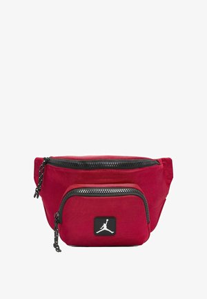 Borsa in tessuto rosso con due compartimenti con zip, zip nere e un prominente patch del logo Jordan nero sul fronte. Design compatto e funzionale.