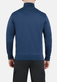 Pull en bleu marine avec col montant, manches longues et ourlet côtelé. Confectionné dans un tissu lisse et respirant, sans logos ni motifs visibles.