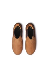 Zapatos marrones de ante sin cordones con acentos elásticos a los lados, punta redondeada y suela de goma. El interior cuenta con un forro de tela oscura y marca.