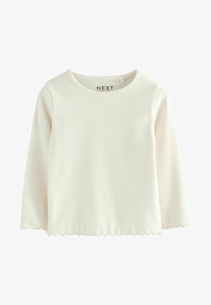 Haut à manches longues blanc à côtes avec un col rond et un ourlet festonné, présentant une finition en tissu texturé. Étiquette de marque "NEXT" à l'intérieur du col.
