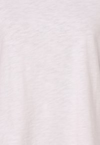 Mjukt vitt tyg med subtil struktur och fin väv, som visar lätta veck och naturlig ljusskuggning.