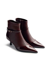 Bottines en cuir bordeaux avec un bout pointu, finition brillante, petits talons kitten et une bride de cheville avec une petite boucle.