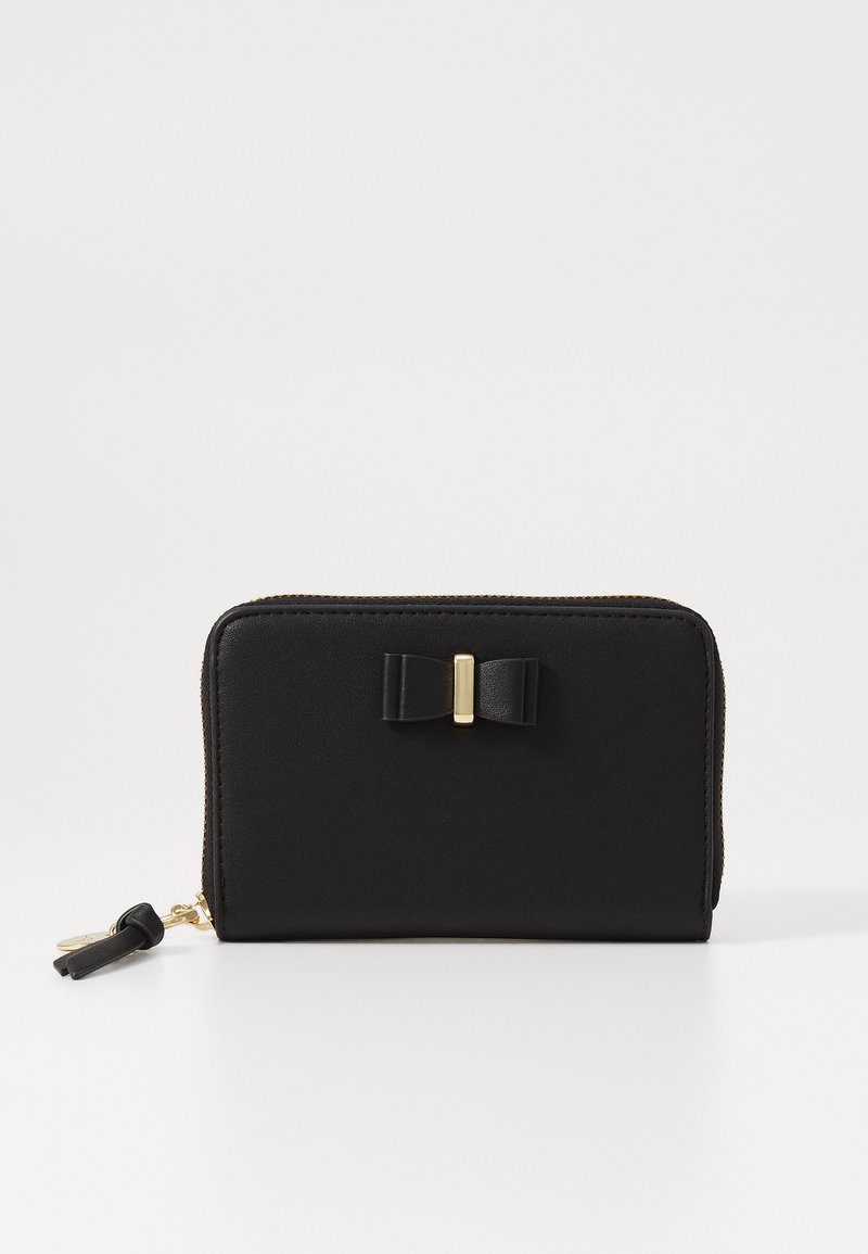 Black wallet made of smooth leather featuring a small bow detail and a gold-tone clasp. Zipper closure with a tassel accent.