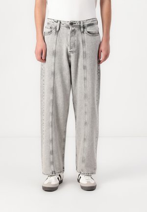 Light gray denim jeans with a loose fit, featuring front pockets, a button fly, and contrasting stitching along the seams.
