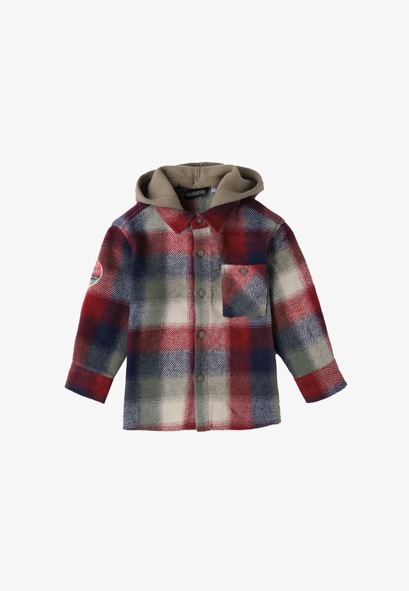 Camicia di flanella con un motivo a quadri rosso, blu e verde, presenta un cappuccio beige e una tasca sul petto. Chiusura con bottoni e maniche lunghe.