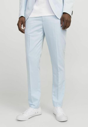Light blue dress pants featuring a tailored fit, creased front, and smooth fabric, paired with white sneakers for a casual look.