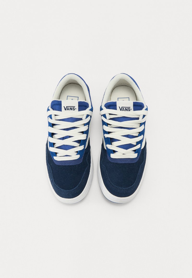 Baskets en daim bleu marine avec des lacets blancs et des semelles en caoutchouc. Présente un logo blanc sur la languette et des perforations près de l'orteil.