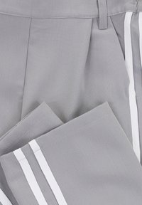 Grijze plissébroek van gestructureerde stof met witte zijstrepen. Voorzien van een platte tailleband en nette stikdetails.