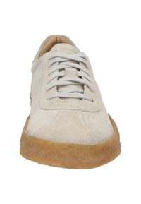 Hellgraue Wildleder-Sneaker mit runder Zehenform, zentralem Schnürdesign und dicker, hellbrauner Gummisohle. Strukturierter Oberstoff mit minimalen Details.