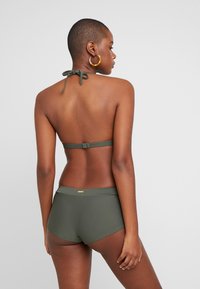 Bikini-Set in Olivgrün, mit Halterneck und Bindeband, passendem Hochbund. Glatte Textur und dezente Markendetails am Bund.