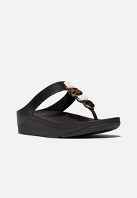 Infradito neri con una soletta testurizzata, cinturini larghi e accenti decorativi in nero e tartaruga. Suola a zeppa leggera.