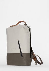 Zaino con una parte superiore grigio chiaro, parte inferiore marrone scuro e una tasca con zip; presenta un manico in pelle e cinghie regolabili.
