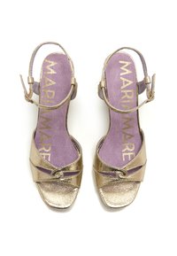 Sandales dorées à lanières avec une finition métallique texturée, présentant un devant croisé et une bride de cheville à boucle. Semelle intérieure rembourrée violette avec logo.