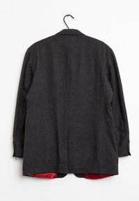 Herre mørkegrå blazer med tekstureret stof, der har en enkelt slids bagpå og rødt for synligt ved kant og indersiden af ærmerne.