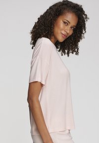 Hele roosa, soonikkoes lühikeste varrukatega T-särk, mis on lõdva lõikega. Ümar kaelus. Sile pind, sobilik vabaajajärgseks kandmiseks.