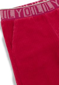 Rode corduroy joggers met een gestructureerd oppervlak, voorzien van zijzakken en een geborduurde tailleband in tinten roze en lichtgroen.