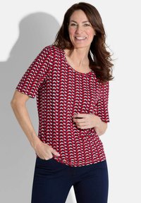 Haut à manches courtes rouge et blanc avec un col rond, présentant une coupe décontractée et un tissu doux et léger.