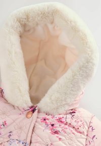 Rosa gesteppte Jacke mit floralem Muster; weiche weiße Kunstfellfüllung um die Kapuze und den Ausschnitt; mit Knopfverschluss.