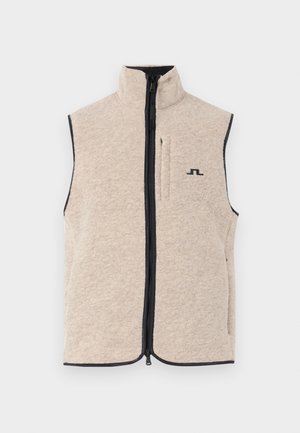 Beige fleece vest with high collar, front zipper, and side pockets; features dark trim and a small black logo on the chest.