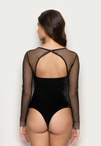 Czarny bodysuit z długimi, dopasowanymi siateczkowymi rękawami. Tył posiada wycięcie w kształcie klucza oraz miękką, welurową teksturę w części ciała.