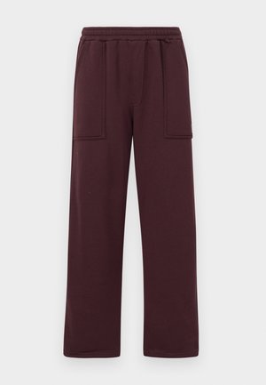 Burgundy sweatpants made of soft cotton blend, featuring a relaxed fit, elastic waistband, and two front pockets with rectangular flaps.