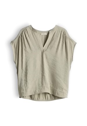Lichtbeige blouse met korte mouwen en V-hals, met geplooide details bij de schouders, losse pasvorm en licht afgeronde zoom, hangend tegen een witte achtergrond.