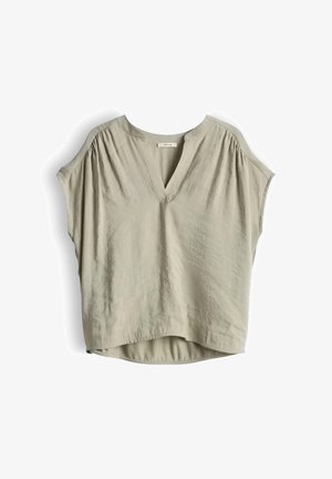 Lichtbeige blouse met korte mouwen en V-hals, met geplooide details bij de schouders, losse pasvorm en licht afgeronde zoom, hangend tegen een witte achtergrond.