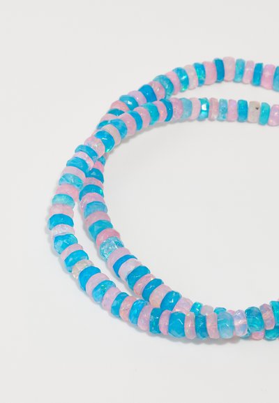 Collier perlé mettant en avant des disques en résine roses et bleus avec une transparence variée et une surface facettée, disposés en motifs alternés.
