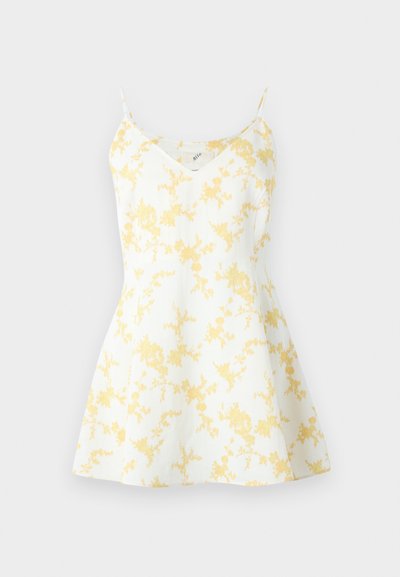 Λευκό αμάνικο φόρεμα με λεπτές τιράντες και κίτρινο floral μοτίβο, με εφαρμοστή μπούστα και φουσκωτή φούστα.