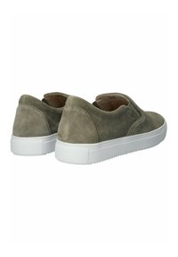 Zapatos de ante tipo slip-on en verde oliva con una suela de goma blanca, que presentan una textura suave y un diseño minimalista. Sin herrajes ni patrones visibles.