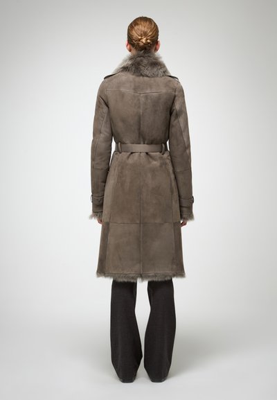 Lang frakke i gråt suede med faux fur-detaljer, bælte i taljen og sidelommer. Har et struktureret design og knapmanchetter.