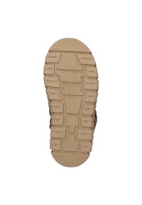 Suela de sandalia de cuero marrón con patrón de agarre texturizado. Presenta ranuras moldeadas y detalles de marca. Perfil plano para estabilidad.