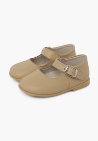 Tan leren Mary Jane schoenen met een scalloped randontwerp, een band met een metalen gesp, een ronde neus en een platte rubberen zool.