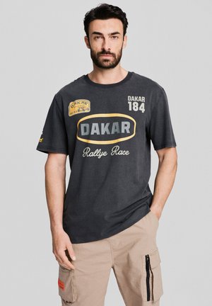 Czarnoszary t-shirt z okrągłym dekoltem, krótkimi rękawami i grafiką z przodu, na której znajdują się napisy "DAKAR", "184" oraz "Rallye Race" w kontrastowych kolorach.